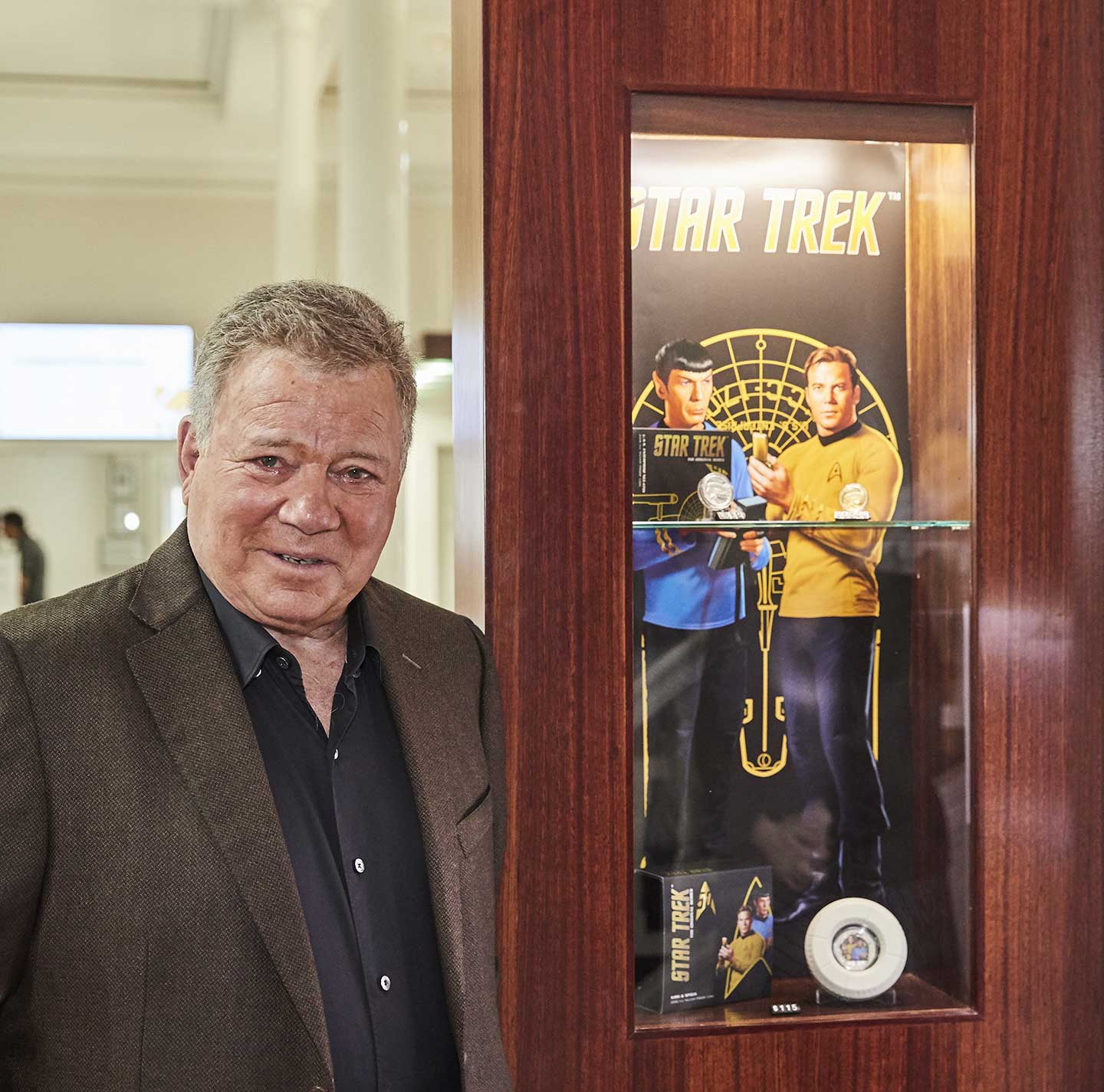 William Shatner standing in front of some Perth Mint issued Star Trek coins